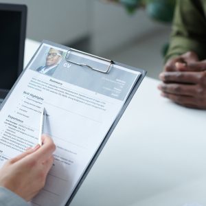 Manager examining resume of candidate Close-up of interviewer examining resume of candidate for a new post during job interview
